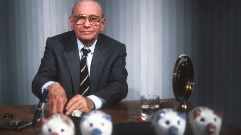 «Welches Schweinderl hätten Sie denn gern?»: Quizmaster Robert Lembke 1985 mit den berühmten «Was bin ich?»-Sparschweinen. - © picture alliance / dpa