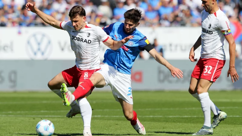 Freiburgs Maximilian Eggestein (l) und Kiels Armin Gigovic kämpfen um den Ball. - © Claus Bergmann/dpa