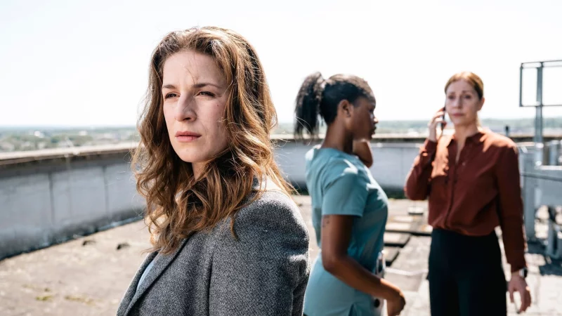 Dina Schwarz (Lou Strenger, links) blickt zu dem am Dach-Rand stehenden Nathan Freye. Im Hintergrund rufen Veronika Jelinek (Ulrike Tscharre, rechts) und Jenny de Luca (Melodie Simina, Mitte) Hilfe. - &copy; Martin Rottenkolber/WDR Kommunikation/Redaktion Bild/dpa