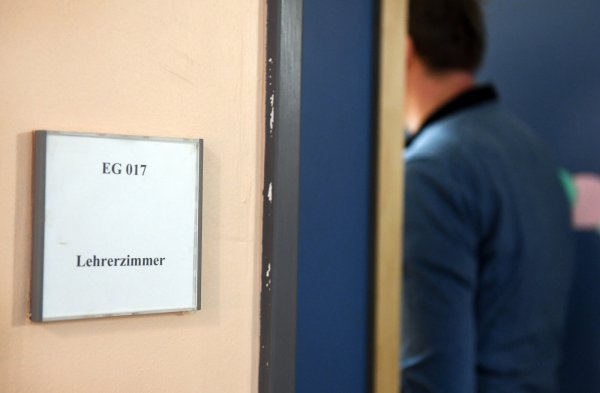 Ein Mann geht an einem Schild vorbei, das den Weg zum Lehrerzimmer weist. Gewalt gegen Lehrer hat laut einer Umfrage unter nordrhein-westfälischen Schulleitern in den vergangenen Jahren zugenommen. - © Maurizio Gambarini/dpa