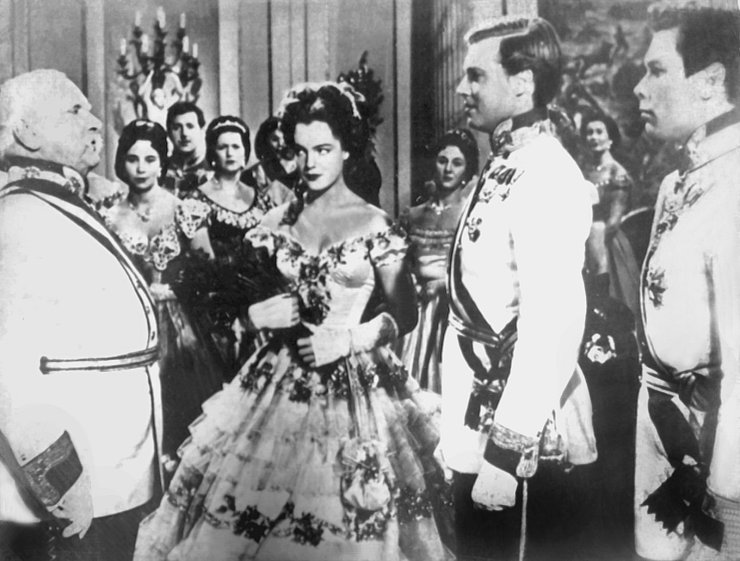 Die Schauspielerin Romy Schneider als Kaiserin Elisabeth (M) und der Theater- und Filmschauspieler Karlheinz Böhm als ihr Gatte Kaiser Franz Joseph von Österreich (2.v.r.) sind in einer Filmszene der "Sissi"-Filmtrilogie zu sehen. - © UPI/dpa