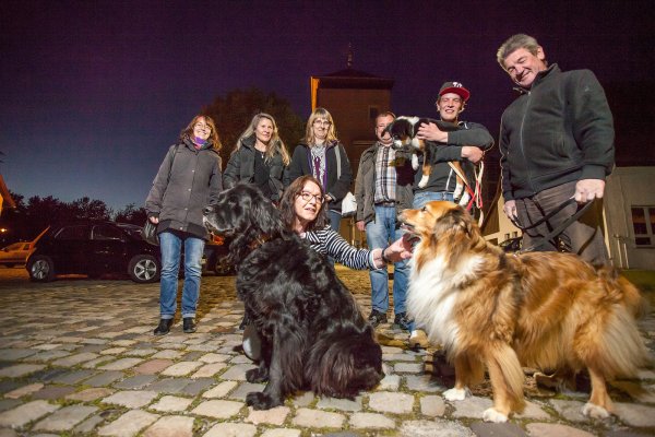 Setzen sich für einen Hundeplatz ein: Nina Henekamp, Marlies Mehrmann, Vera May (sitzend), Martina May Dirk Hennekamp, Gerhard und Ansgar May (von links) mit den Hunden Sam, Kimberly und Stine vor der Burgscheune. - © Torben Gocke