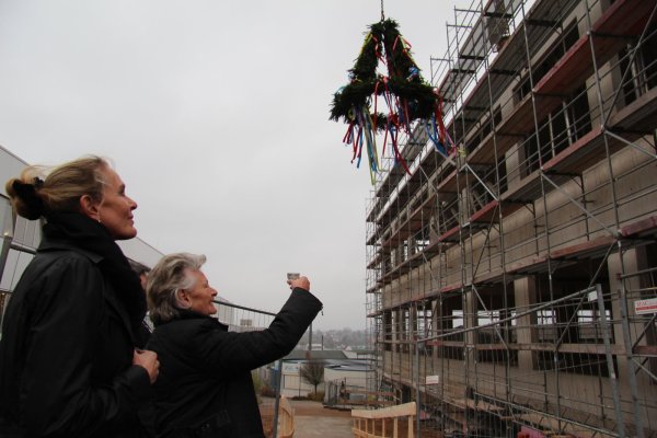 Den Richtkranz im Blick: Gesellschafterin Klara Niehus (geborene Brasseler) hebt ein Glas vor dem Neubau. Links im Bild steht ihre Tochter  Anke Niehus. - © Thomas Reineke
