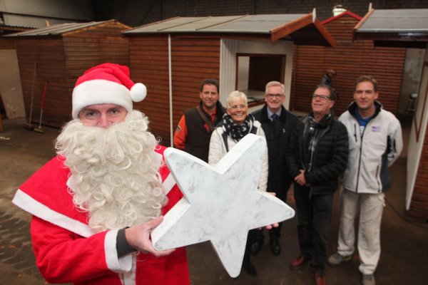 Im Kostüm: Weihnachtsmann Markus Schapeler freut sich mit einem Deko-Stern in der Hand genau so auf das neue Weihnachtsmarkt-Konzept wie Martin Klein, Angelika Drowe, Thomas Voss, Dieter Grittern und Thomas Stenzel (hinten, von links). Im Hintergrund sind die Buden zu sehen, die derzeit aufgearbeitet werden. - © Patrick Bockwinkel