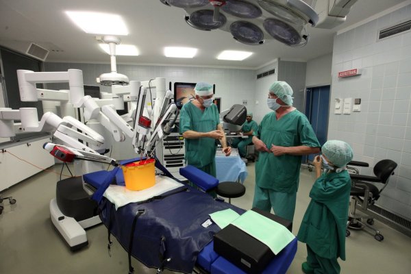 Pressetermin im OP-Saal: (von links) Chefarzt Dr. Alfons Gunnemann erklärt seinem Patienten Joachim Schlingmann, der mit Enkel Leonard gekommen ist, die Funktionsweise des Roboters. Im Hintergrund sitzt Oberarzt Ihab Abutabanjeh am Bildschirm der Maschine. - © Bernhard Preuß
