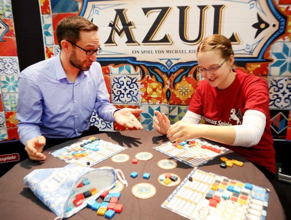 Das Spiel «Azul» mit der Auszeichnung «Deutscher Spielepreis 2018» in der Kategorie Familie und Erwachsene testen zwei spielbegeisterte Standmitarbeiter.  - © Roland Weihrauch/dpa