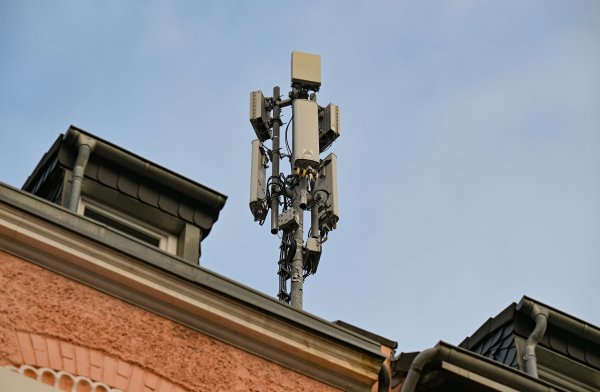 Ein Mobilfunkmast mit 4G/LTE-Antennen (länglich) und 5G-Antennen (quadratisch) steht auf einem Dach eines Wohnhauses. - © Wolf von Dewitz/dpa