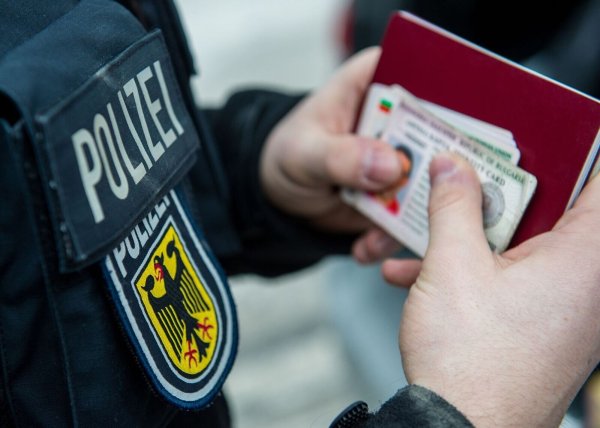 Ein Beamter der Bundespolizei hält bei einer Kontrolle ausländische Ausweise in den Händen. - © Marc Müller/dpa