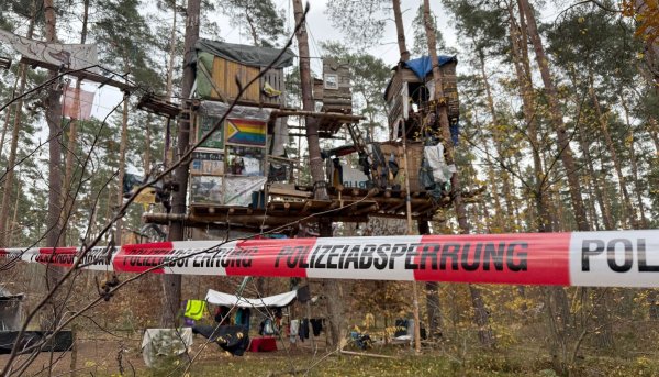 Tesla-Gegner müssen für eine Kampfmittelsondierung einen Teil ihres Protestcamps im Wald verlassen. Die Polizei ist im Einsatz. - © Lutz Deckwerth/dpa