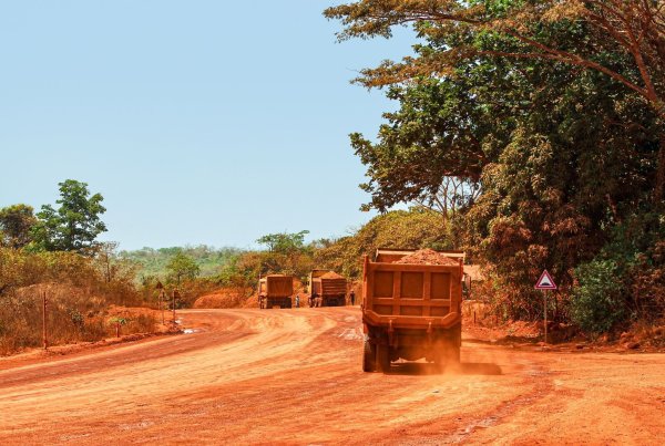 Lastwagen transportieren Bauxit entlang einer Bergbau-Transportstraße. Laut einer Studie werden mehr als ein Drittel der Menschenaffenpopulation in Afrika durch Bergbau gefährdet. - © Claude Frenette/iDiv/dpa