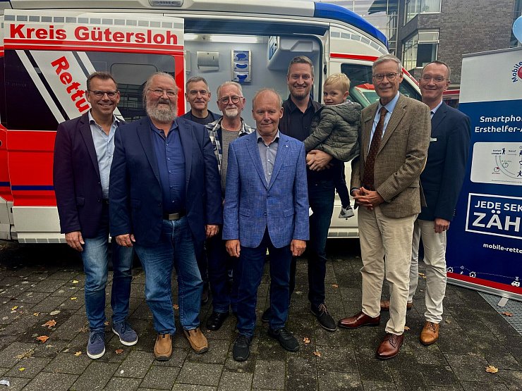 Thomas Kuhlbusch (v.l), Dezernent, Kreis Gütersloh, Detlef Vincke Überlebender, Ralf Stroop, Entwickler und Ideengeber, Andreas Lekic, Überlebender, Heinrich Harbrock, Überlebender, Alexander Bloch, Überlebender, und Bernd Strickmann, Ärztlicher Leiter des kreiseigenen Rettungsdienstes, feiern gemeinsam mit Landrat Sven-Georg Adenauer (2.v.r.) vor dem Kreishaus. - © Danielle Dörsing
