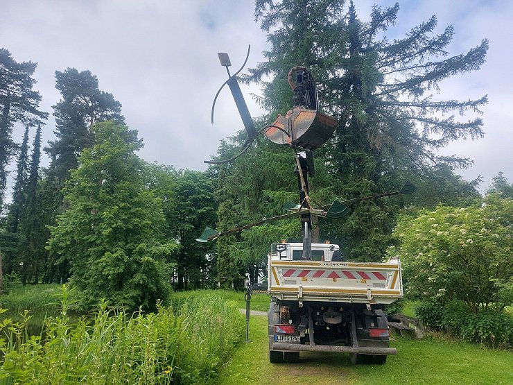 Mit einem Langarm-Bagger hieven die Mitarbeiter des Bauhofes den "Teichläufer" wieder ins Wasser. - © Michaela Weiße
