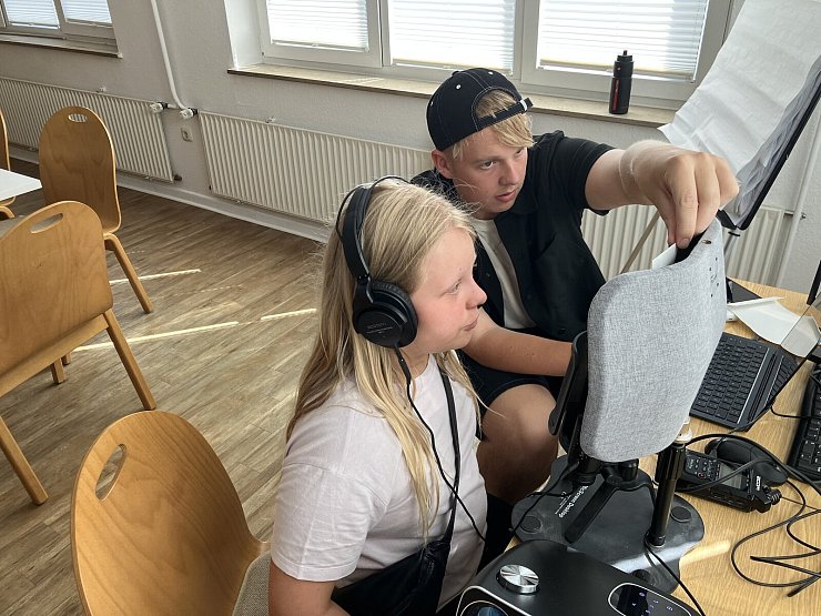 Jannis Jürgens unterstützt Guilia beim korrekten Einsprechen der Moderationstexte. - © SOS-Kinderdorf