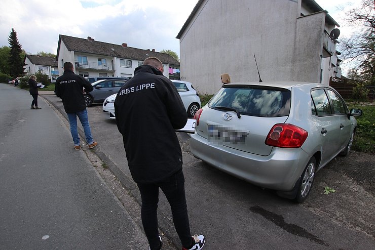 Mitarbeitende des Straßenverkehrsamts des Kreises Lippe kontrollieren die Kennzeichen der Autos in der Siedlung. - © Ordnungspartnerschaft Augustdorf