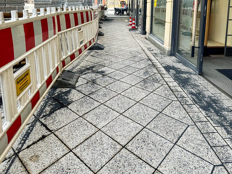 Vor den Hauseingängen nahe dem Eiscafé sind die ersten neuen Steine bereits verlegt worden. Der Übergang von Diagonal- zu Reihenverband ist gut zu erkennen. - © Raphael Bartling