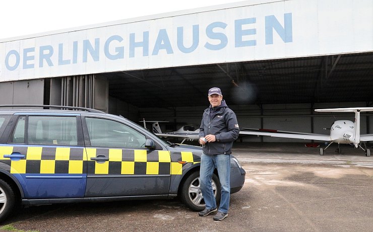 Rolf Tiemyer vor seinem "Firmenwagen" und vor der Halle der Segelflugschule. - © Oliver König