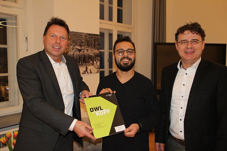 Bürgermeister Frank Hilker (links) und GILDE-Geschäftsführer Thorsten Brinkmann begrüßen Alhausien Althalgi (Mitte) im Rathaus. - © Stadt Detmold