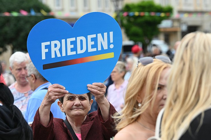 01.07.2023, Sachsen-Anhalt, Magdeburg: Eine Teilnehmeri, der AfD-Kundgebung in der Landeshauptstadt hält ein blaues Herz mit einer Friedenstaube. Auf der Kundgebung haben AfD-Landes- und Bundespolitiker die Europäische Union kritisiert und Veränderungen gefordert. Foto: Heiko Rebsch/dpa +++ dpa-Bildfunk +++ - © Heiko Rebsch