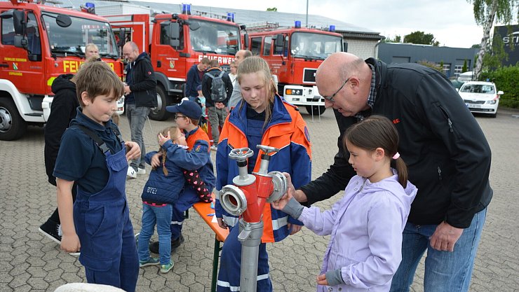 Sofia (7) schraubt gewissenhaft Teile an ein Strahlrohr. Ihr Vater Michael Bröker hilft mit. Die beiden Jugendfeuerwehrleute Fabian Güse (11) und Josephine Schurig (13) betreuen die fünfte Stadtion der Olympiade. - © Karin Prignitz