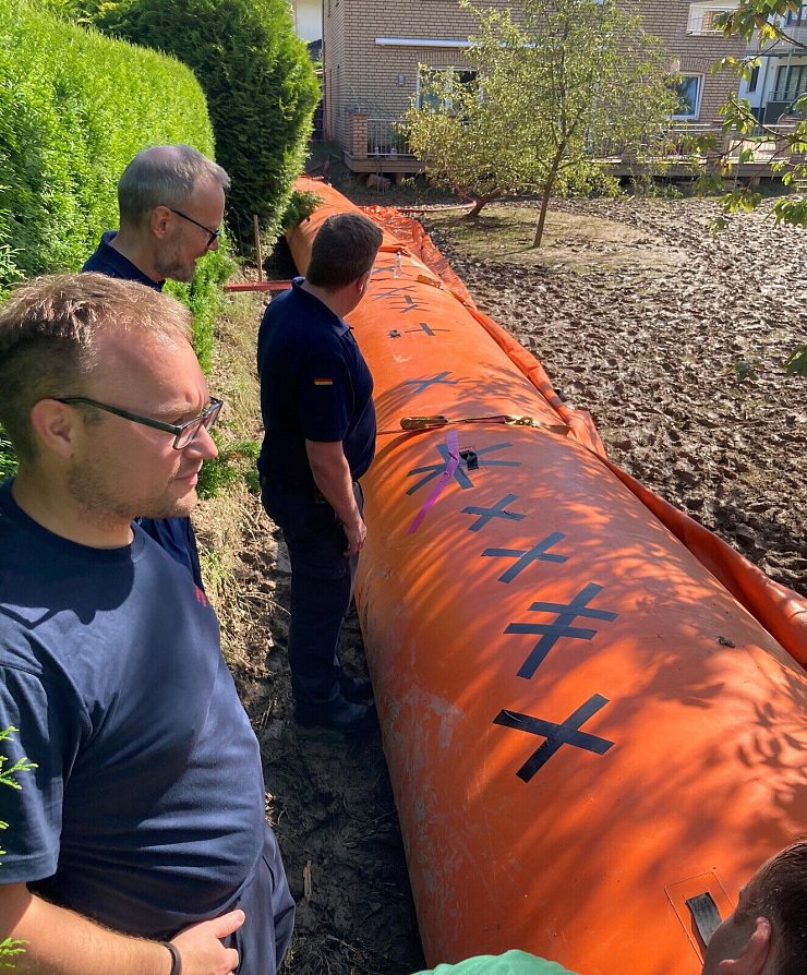 THW-Ortsbeauftrager Dominik Grewe und THW-Fachberater Thorsten Meier nehmen gemeinsam mit Jörn-Henner Koch von der Feuerwehr Detmold den Beaver-Damm in Augenschein. - © Stadt Detmold