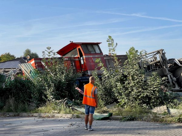 Teile eines entgleisten Güterzuges sind hinter Sträuchern zu sehen. - © Christian Müller/Westfalennews/dpa