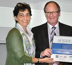 Barbara Steffens &uuml;berreicht Dieter Hortskotte vom Herzzentrum die Auszeichnung.