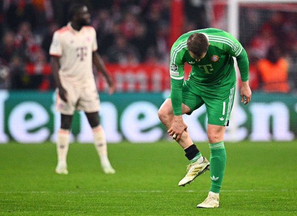 Manuel Neuer fasst sich an die verletzte Wade. - © Tom Weller/dpa