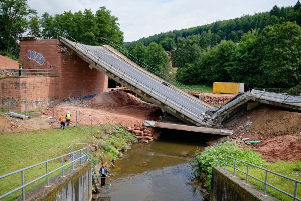 Die Brücke stürzt durch Sprengung ein - © Uwe Anspach/dpa