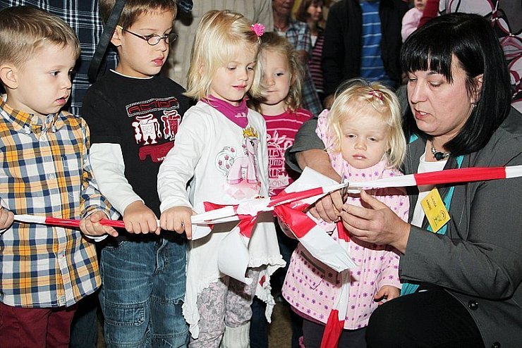 Henrik Schrage (von links), Felix Drösler, Soraya Hannig und Lea Eckelt können es kaum erwarten, mit der Kita-Leiterin Claudia Märzke das Band durchzuschneiden. - © Foto: Stork