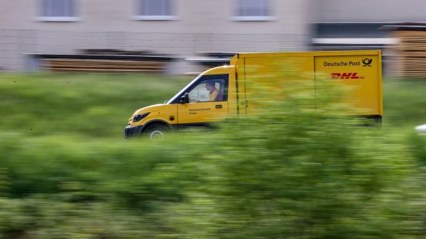 Ein Zusteller des Post-Konzerns DHL stellt mit einem elektrisch betriebenen Fahrzeug (Streetscooter) Post zu. - © Jan Woitas/dpa