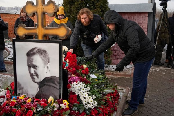 Menschen legen ein Jahr nach dem Tod des russischen Oppositionsführers Alexej Nawalny auf dem Borisowskoje-Friedhof in Moskau Blumen an seinem Grab nieder. - © Uncredited/AP/dpa