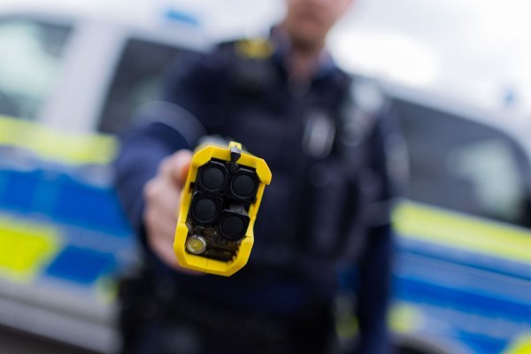Ein Polizist hält einen Taser («Distanzelektroimpulsgerät») in den Händen - © Rolf Vennenbernd/dpa