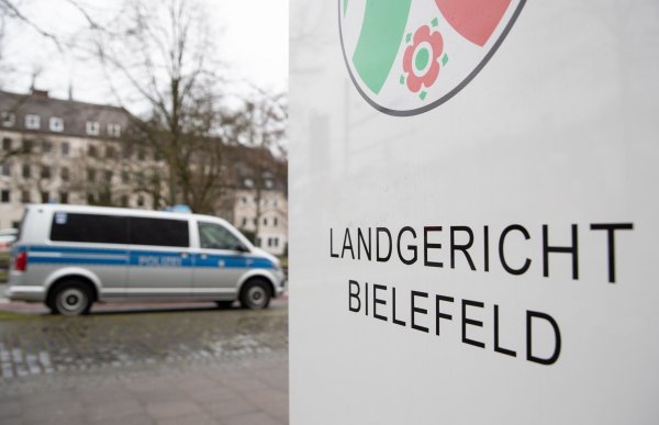 Ein Polizeibus steht vor dem Landgericht Bielefeld. - © Friso Gentsch/dpa