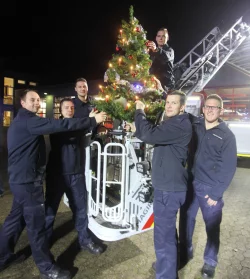 Licht an: Fürs Foto schmücken Florian Schmidt, Christian Baier, Michael Reger, Timo Wessel, Michael Bohr und Martin Deppe einen künstlichen Tannenbaum, der auf der Drehleiter der hauptamtlichen Wache montiert ist. - © Daniel Hobein