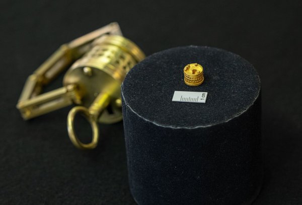 So winzig: Das römische Miniatur-Schloss liegt neben einem Maßstab für einen Zentimeter. Im Hintergrund der Nachbau im Verhältnis 4:1. - © Guido Kirchner/dpa