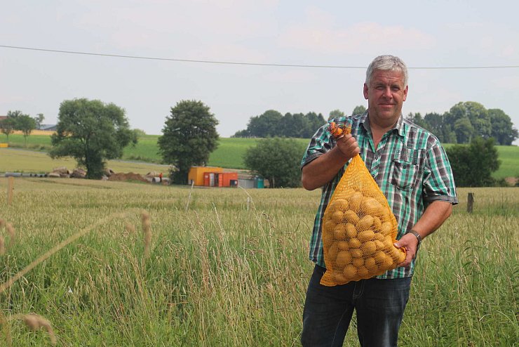 Kartoffelbauer: Joachim Altrogge steht mit einem Sack Kartoffeln an seinem Hof. Hinter ihm ist die Baustelle des neuen Kreisels an der Einmündung der Felix-Fechenbach-Straße auf die Straße An der Windwehe zu sehen. Auf Altrogges Hof stranden immer wieder Autofahrer, die die Sperrung nicht wahrhaben wollen. - © Thomas Dohna