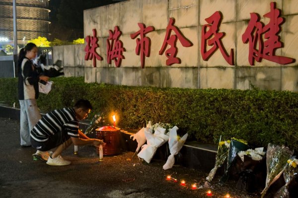 Menschen legen Blumen vor einem Sportzentrum nieder, wo ein Mann mit seinem Auto 35 Menschen tötete. - © Ng Han Guan/AP