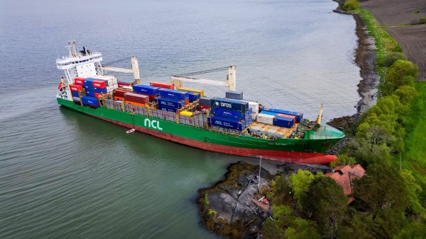 Ein Containerschiff ist in Norwegen kurz vor einem Haus am Wasser zum Stehen gekommen. - © Jan Langhaug/NTB/dpa