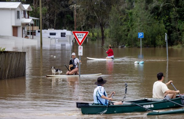Viele Menschen konnten sich nur noch mit Booten und Paddleboards fortbewegen. - © Lindsay Moller/AAP/dpa
