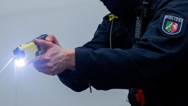 Ein Polizist mit einem «Distanzelektroimpulsgerät», auch Taser genannt. (Archivbild) - © Rolf Vennenbernd/dpa