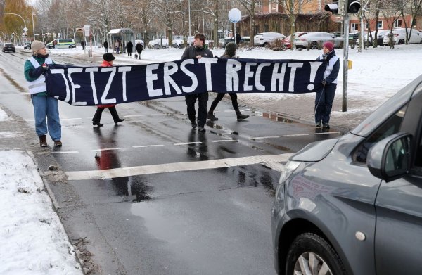 Mitglieder der «Letzten Generation» blockieren während des Prozesses in Stralsund eine Straße. - © Bernd Wüstneck/dpa