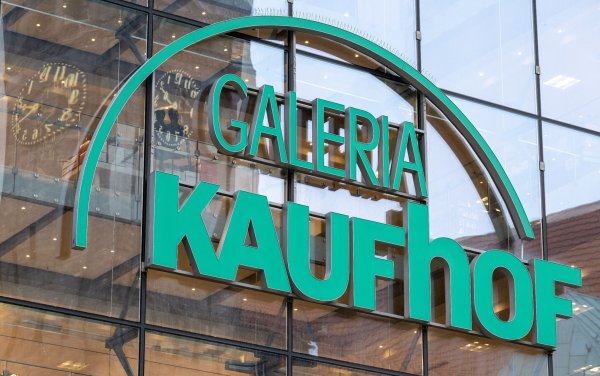 Die Uhr des Neuen Rathauses spiegelt sich im Logo der Galeria Kaufhof im Zentrum von Chemnitz. - © Hendrik Schmidt/dpa/Archivbild