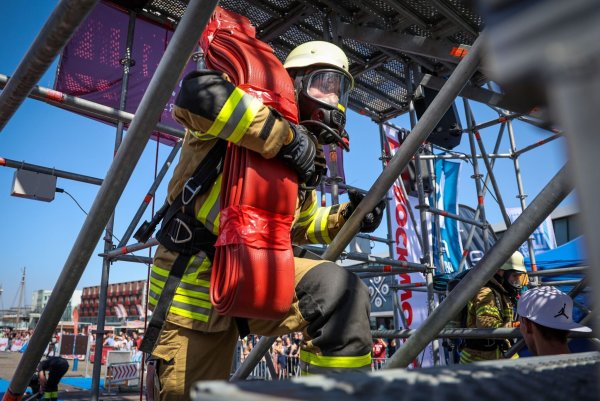 Der Feuerwehrmann Philipp Reumann von der Freiwilligen Feuerwehr Eckwarden steigt bei der «Firefighter Combat Challenge» in Bremerhaven mit einem Schlauch auf einen Turm. - © Focke Strangmann/dpa