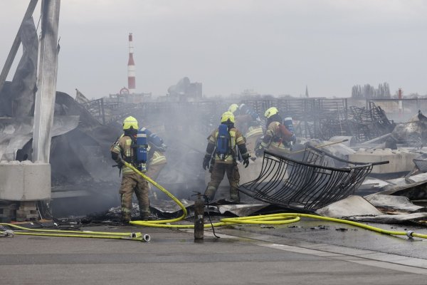 Die Feuerwehr löscht die Brandstelle bei der Flüchtlingsunterkunft am ehemaligen Flughafen Tegel. Die Nachlöscharbeiten sind inzwischen abgeschlossen. - © Carsten Koall/dpa