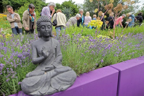 Die Ruhe selbst: Viele Duftpflanzen im Taoasis-Garten haben beruhigende Wirkung. Der steinerne Budda sieht das Treiben der Besucher gelassen. - © Bernhard Preuss