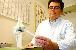 Medizinische Kapazität in der alten Hansestadt: Dr. med. Hans-Gottfried Braun, leitender Arzt des Gelenkzentrums, erklärt eine Behandlungsmethode an einem Modell. - © Foto: Blum