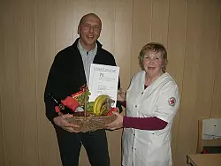 Großer Präsentkorb mit Ehrennadel und Urkunde: Detlef Tölle und Eta Rieks (von links). - © Foto: privat