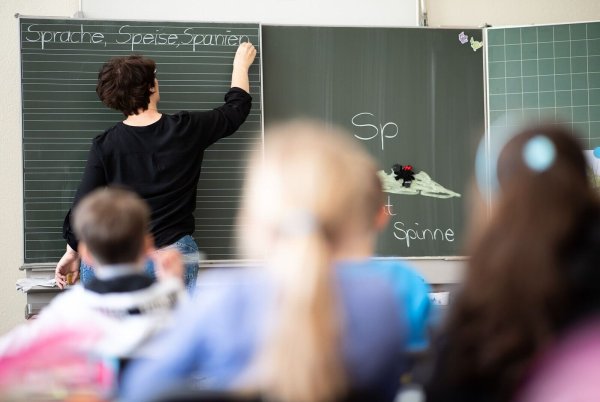Eine Lehrerin schreibt in einer Grundschule an eine Tafel. - © Sebastian Gollnow/dpa/Symbolbild