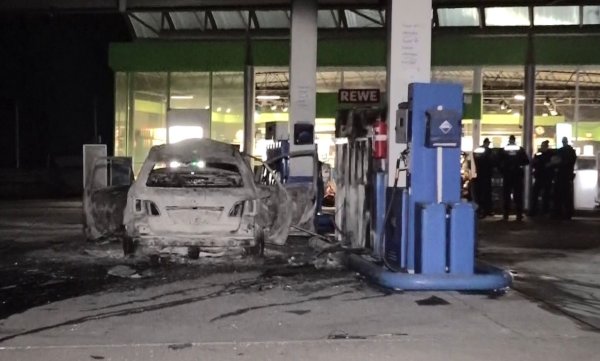 Ein ausgebranntes Fahrzeug steht an einer Zapfsäule auf einer Tankstelle in Hannover. - © -/dpa