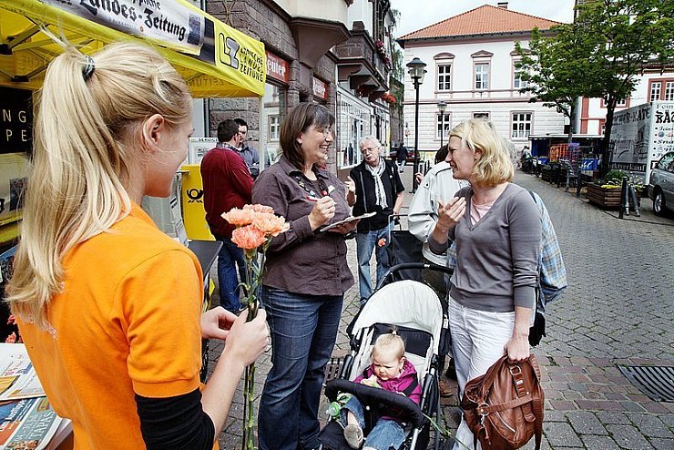 Viel Gesprächsbedarf: Carly Feenstra (rechts) erzählt LZ-Redakteurin Marianne Schwarzer, was sie sich wünscht, während Kerstin Nolte (links) Nelken verteilt. - © Foto: preuss